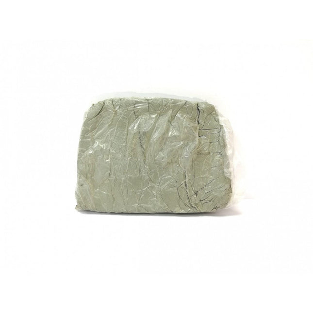 Bloque de arcilla artística gris envuelta en plástico, ideal para modelado y proyectos escolares, sobre fondo blanco.