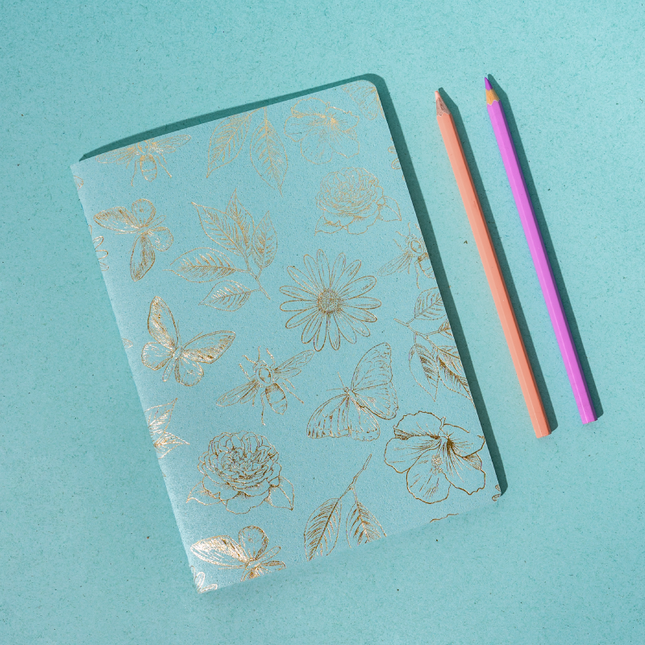 Libreta Econotas Alpen 15×21 cm azul con estampado de flores y mariposas en foil dorado y 32 hojas ecológicas cosidas en hilo.